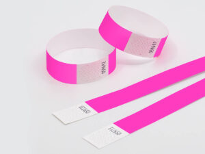 Neon pink Tyvek wristbands with sequential numbering. High visibility bands for parties and concerts. Manufacturer AMGS Group.