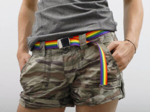 Custom belt with sublimation rainbow print and metal buckle worn with casual pants.