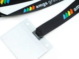 A detailed close-up shot demonstrating how the r-PET lanyard tape loops through the badge holder slot for a secure fit.