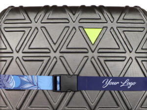 Personalized luggage strap with corporate logo secured around a grey textured suitcase, aiding easy baggage identification.